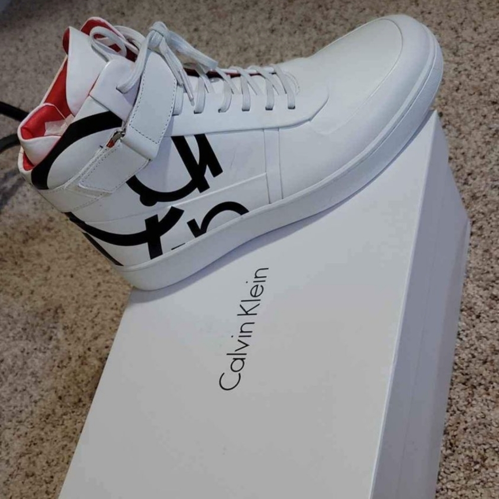 New in box. Calvin Klein high top white w/black lettering. Size 7.5 mens